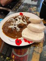 道伊斯Jasmin Czechinn的桌子上放着一盘食物，里面有辣椒和面包。