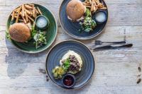 una mesa con tres platos de comida y papas fritas en Hotel Kuusamon Portti, en Kuusamo