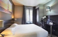 a hotel room with a bed and a desk and a window at Jardin de Villiers in Paris