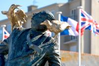 a statue of a man with two birds and flags at Bella Cruz - Charmant appt à Dinard in Dinard
