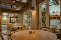 a restaurant with tables and chairs and large windows at Pelangi Beach Resort & Spa, Langkawi in Pantai Cenang