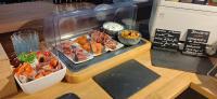 a display case with sushi and other food items at Logis Le Saint Hubert in Haybes
