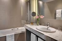 a bathroom with a sink and a mirror and a tub at Splendid Etoile in Paris