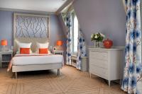 a bedroom with a large bed with orange pillows at Splendid Etoile in Paris