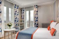 a bedroom with a bed and a table and a window at Splendid Etoile in Paris