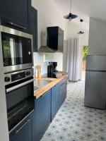 a kitchen with blue cabinets and a stove top oven at Chez Mélanie, près de l’abbaye in Jumièges