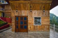 un edificio de madera con una puerta en un patio en La Das Treetops, en Kurseong