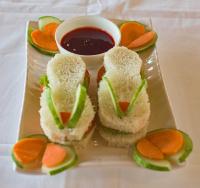 Un plato con sándwiches y un tazón de salsa para mojar. en La Das Treetops, en Kurseong