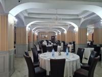 a banquet room with tables and chairs and a chandelier at Hotel Valahia in Târgovişte