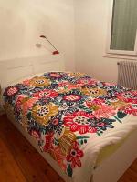 a bed with a colorful blanket on top of it at Appartement lumineux Vue montagne Centre Grenoble in Grenoble