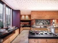 Una cocina con paredes de madera y un mostrador con comida. en Falkensteiner Hotel Schladming, en Schladming