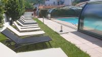 a row of lounge chairs next to a swimming pool at Hotel Eskualduna Chez Katina in Saint-Martin-dʼArrossa
