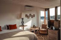 a bedroom with a bed and a chair and a window at Surplage Hotel Cavalière in Le Lavandou