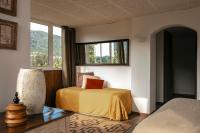 a bedroom with a bed and a window at Surplage Hotel Cavalière in Le Lavandou