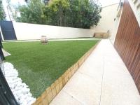 a garden with a retaining wall and a lawn at Gîte Riad 4 personnes in Narbonne