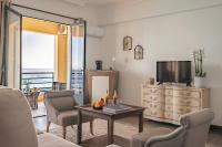 a living room with a television and a table at Surplage Hotel Cavalière in Le Lavandou