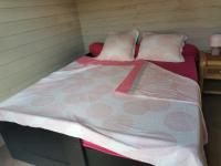 a large bed with pink and white sheets and pillows at MAISON &amp; PISCINE PRIVES,PLAGES OCEAN ET LAC A 10 kms in Linxe