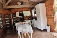 a kitchen with a table and a refrigerator at MAISON &amp; PISCINE PRIVES,PLAGES OCEAN ET LAC A 10 kms in Linxe