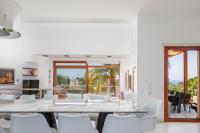 a dining room with white chairs and a large table at Angels Villa in Kambánion