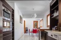 a kitchen with black cabinets and red chairs at Angels Villa in Kambánion