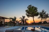a swimming pool with a sunset in the background at Angels Villa in Kambánion