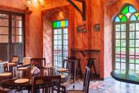 comedor con mesas, sillas y vidrieras en Silva Heritage Resort Goa, en Benaulim