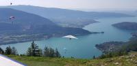 a view of a lake with people flying kites over it at La petite Anfiane in Le Grand-Bornand