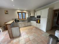 a kitchen with white cabinets and a tile floor at le Pigeonnier gersois in Condom