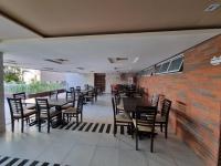 Un restaurante con mesas y sillas y una pared de ladrillos. en Apt pé na areia ao lado do Beach Park no Porto das Dunas, en Aquiraz