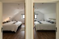 two beds in a room with two windows at Vakantiehuis Paula in Watervliet
