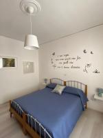 a bedroom with a bed with blue sheets and words on the wall at Casa Matilde in Capaccio-Paestum