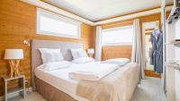 a bedroom with a bed with white sheets and a window at Le Theven in Sibiril