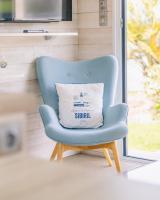 a blue chair with a pillow sitting in front of a window at Le Theven in Sibiril