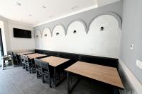 a row of tables in a restaurant with arched windows at Prime Hotel in Gyumri