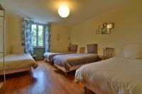 a hotel room with three beds and a window at Gite de groupe &quot;L&#39;Unisson&quot; Domaine La Rose des Vents in Castelnau-sur-lʼAuvignon