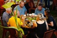 a group of people sitting around a table eating at Ba Be Jungle Houses in Ba Be