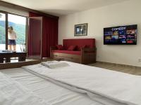 a bedroom with a large bed and a red couch at Dunavska Vila Milosavljevic in Donji Milanovac