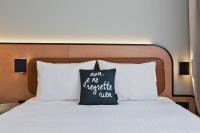 a bed with a pillow that says not to me anything new at Moxy Paris Bastille in Paris