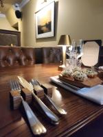 Una mesa de madera con cubiertos encima de una mesa. en The Fanny Talbot, en Barmouth