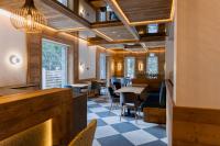 a restaurant with wooden ceilings and tables and chairs at Hotel INA in Borşa