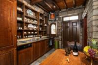 cocina con armarios de madera y mesa de madera en The Treasure Box - Private Stone Villa, en Plaka Milou