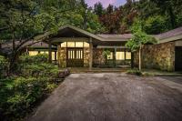 ein Steinhaus mit einer Einfahrt davor in der Unterkunft Bourbon Hollow Lodge with Hot Tub and Pool plus Game Room only 5 min to downtown in Gatlinburg