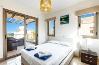 a bedroom with a bed and a balcony at Villa Prosperity Limni by Villa Plus in Mavroli