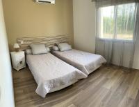 two beds in a small bedroom with a window at A PIAZZOLA in Petreto-Bicchisano