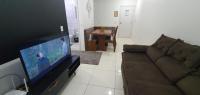 a living room with a couch and a flat screen tv at Condomínio Residencial Mar Azul in Imbituba