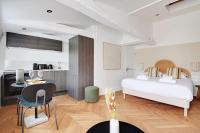 a bedroom with a bed and a table and a kitchen at Brand New Modern Studio in Central Paris - 2P - B6 in Paris