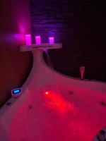 a table with pink lights on top of a bath tub at HomeSparadise Loveroom in Besançon