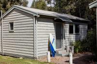 a small shed with a surfboard sitting in it at Lorne Foreshore Caravan Park in Lorne