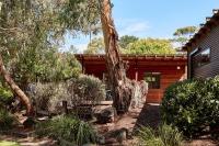 a house with a tree in front of it at Lorne Foreshore Caravan Park in Lorne
