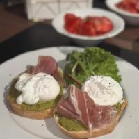 un piatto bianco con due panini con carne e panna montata di Grey Residence Apartament a Târgu-Mureş